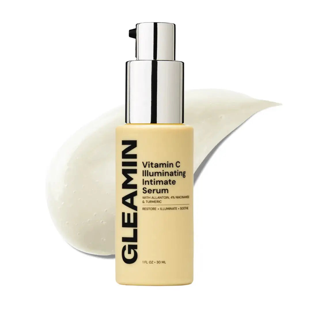 Gleamin Illuminating Intimate Serum body oil in beige bottle with pump, shown beside a white cream smear.