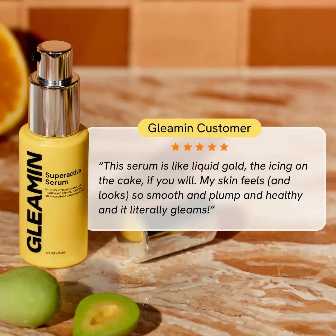 Gleamin Superactive Serum bottle on marble countertop; yellow face serum with silver pump.