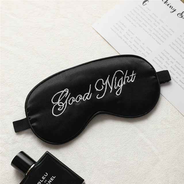 Eye mask and small bottle; black silk with white Good Night embroidery; cooling feature.